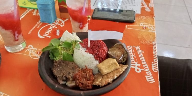 Ria menikmati sajian nasi merah putih yang disajikan warung makan Sambel Pe Simbok di Jalan Penjawi Pati kemarin.