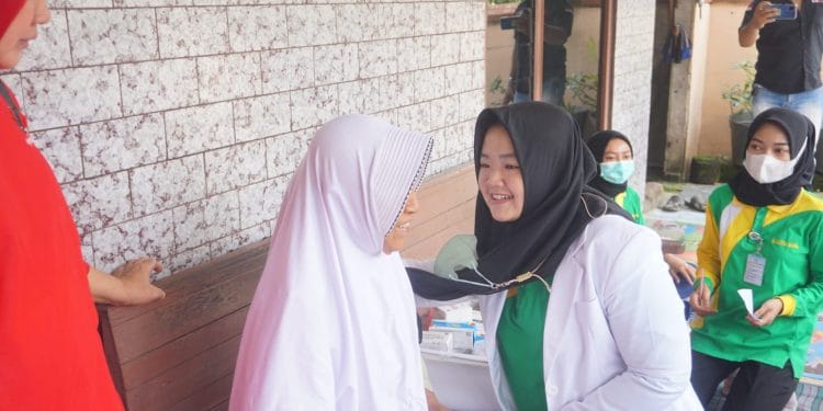 MENGABDI : Dokter Mega Anggun Sylvia sedang melayani warga dalam kegiatan pengobatan gratis belum lama ini. Sosok Mega Anggun Sylvia, Dokter Muda yang Berjiwa Sosial Tinggi
