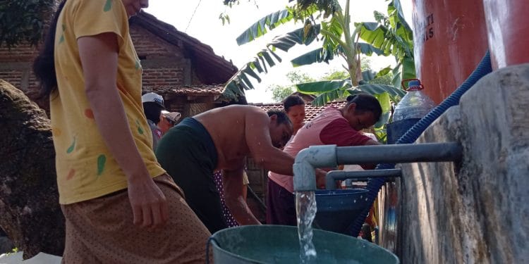 Warga sedang mengantre bantuan air bersih akibat kekeringan.