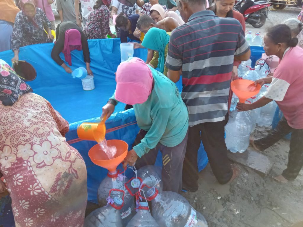 Warga mengantre air bersih yang dibagikan oleh Deddy Gunawan.